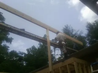 Carpenter setting a ridge beam over a new addition frame — Ice Dam Removal by Roofing Brothers in New Gretna