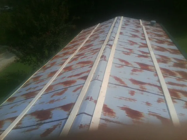 Rusted metal roof panels with new wood purlins before replacement — Storm Damage Roof Repair in New Gretna by Roofing Brothers