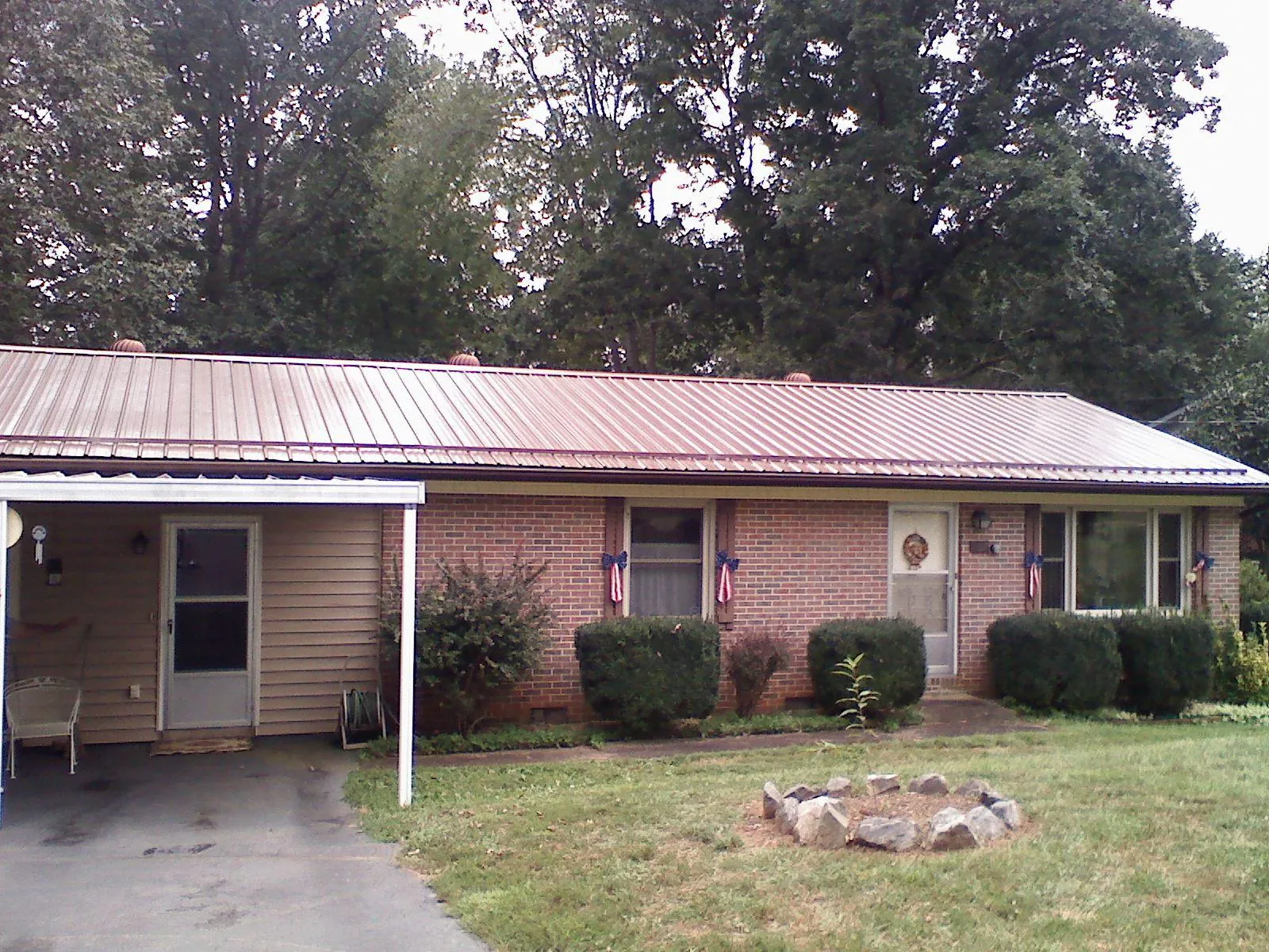 Bronze metal roof and carport on a brick ranch home — Roof Repair work by our crew in New Gretna